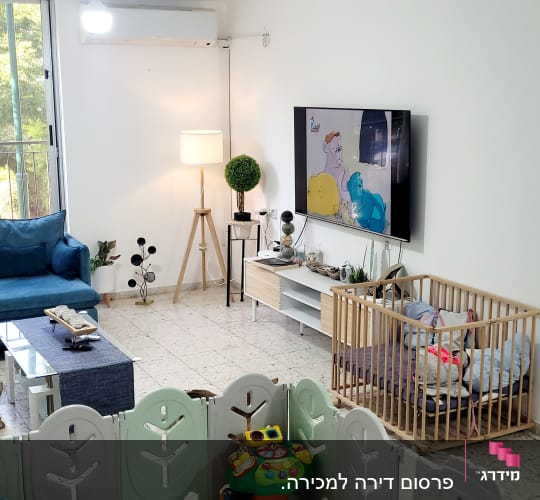 סלון עם ספה, טלוויזיה, וצעצועים לתינוק